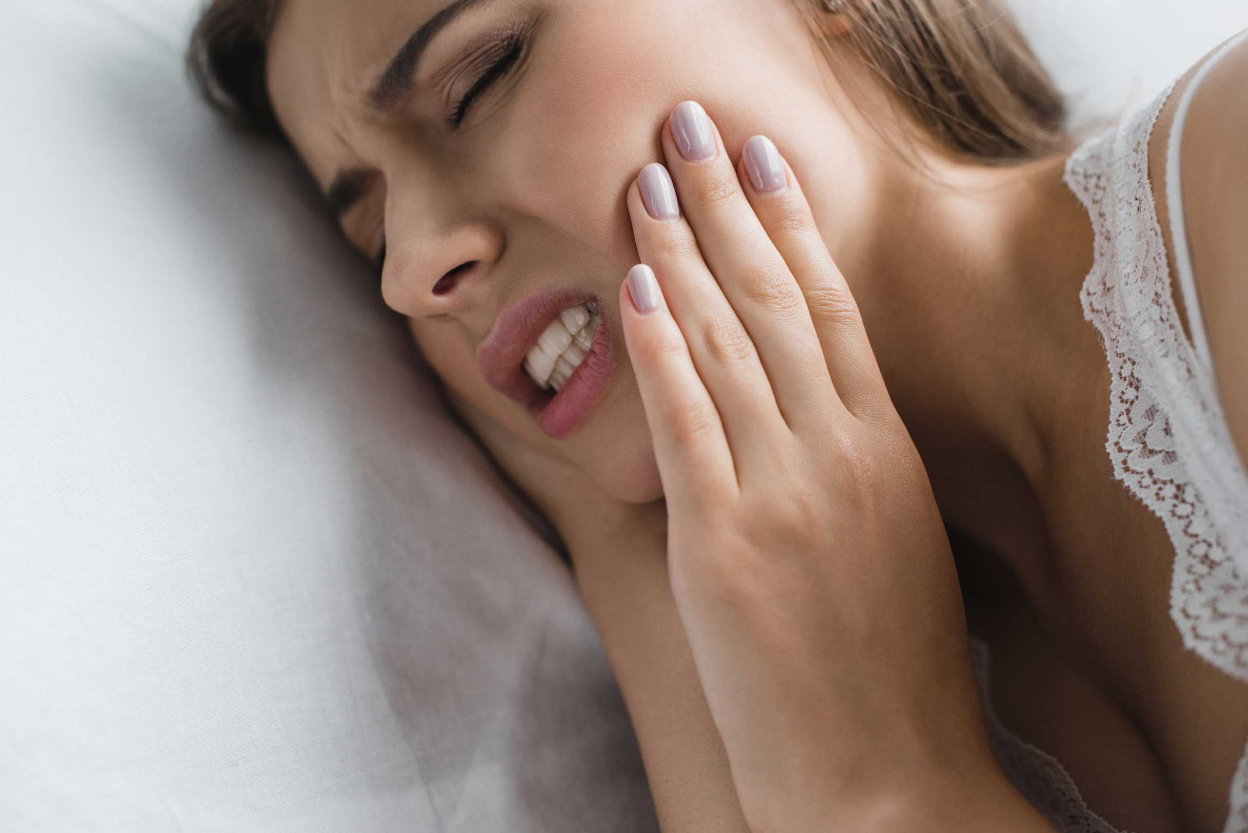 Woman touching her jaw because of discomfort